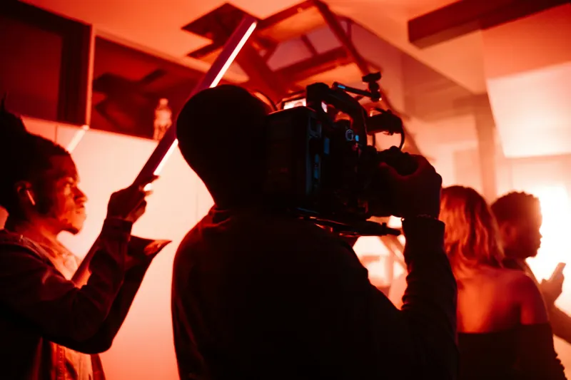 Cameraman filmt in rood licht op een set